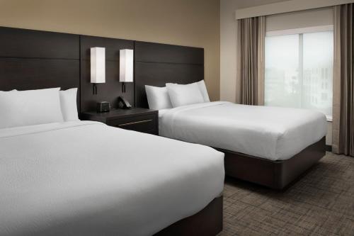杰克逊维尔Residence Inn by Marriott Jacksonville Downtown的酒店客房设有两张床和窗户。