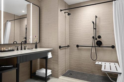 沃瓦托萨Renaissance Milwaukee West Hotel的带淋浴和盥洗盆的浴室