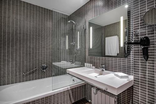 布尔戈斯布尔戈斯AC酒店，万豪酒店的一间带水槽、浴缸和镜子的浴室