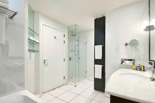 里昂里昂塞特万豪国际酒店的带淋浴和盥洗盆的白色浴室