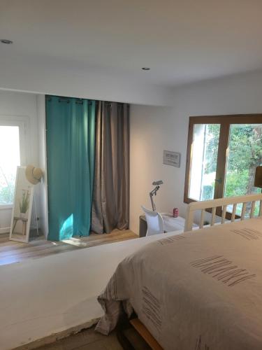 BastelicacciaBas de villa proche Ajaccio的一间卧室配有一张蓝色窗帘的床