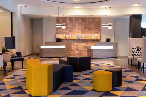 苏黎世北苏黎世万怡酒店的大堂设有黄色和蓝色的桌椅