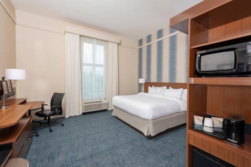 卡梅尔Fairfield Inn & Suites by Marriott Indianapolis Carmel的酒店客房,配有床和电视