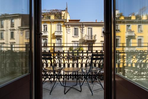 米兰帕妮萨酒店的阳台配有桌椅,享有风景。