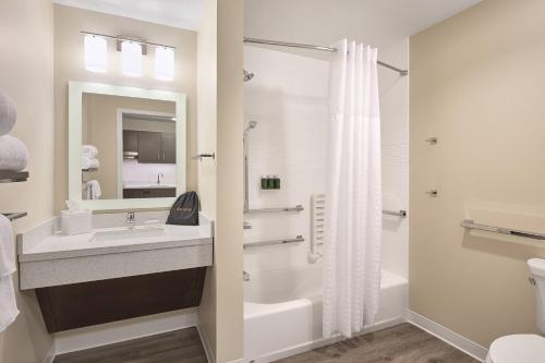 梅迪辛哈特TownePlace Suites by Marriott Medicine Hat的白色的浴室设有水槽和淋浴。
