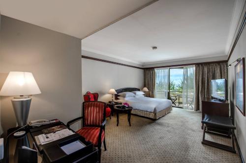 米里美里万豪度假酒店的酒店客房配有一张床、一张书桌和一台电视。