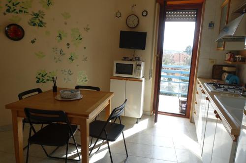 罗马MomòHouse - 4 ospiti 2 camere WiFi A/C的厨房配有桌椅和微波炉。