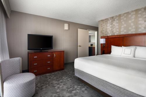 诺瓦托诺瓦托马林/索诺玛万怡酒店的一间卧室配有一张床、一台电视和一把椅子