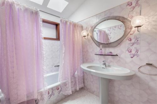 滨海帕尔姆Chalet Umbelina con jardin y vista al mar的粉红色的浴室设有水槽和镜子