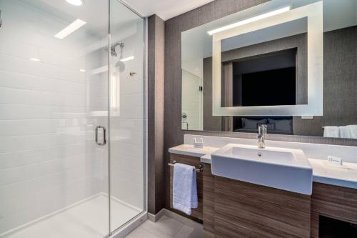 奥克兰SpringHill Suites by Marriott Oakland Airport的一间带水槽、淋浴和镜子的浴室