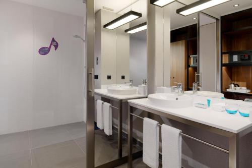 慕尼黑慕尼黑雅乐轩酒店的浴室设有2个水槽和2面镜子
