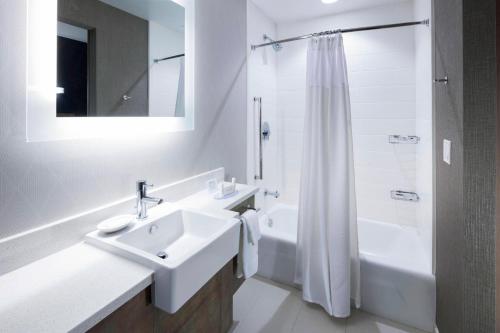 克利尔沃特万豪克利尔沃特海滩斯普林希尔套房酒店的白色的浴室设有水槽和淋浴。