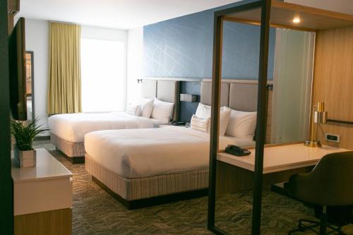 南本德SpringHill Suites by Marriott South Bend Notre Dame Area的酒店客房配有两张床和一张书桌
