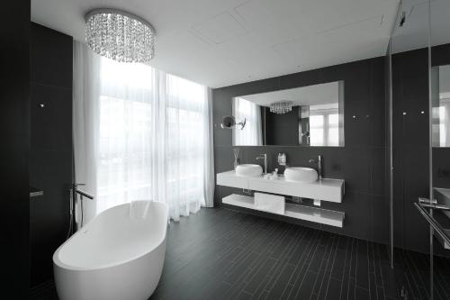 格拉特布鲁格苏黎世波恩卡梅哈格兰德签名收藏酒店的带浴缸、水槽和镜子的浴室