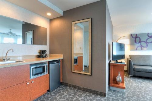 蒙特利尔SpringHill Suites by Marriott Old Montreal的一个带水槽和镜子的小厨房