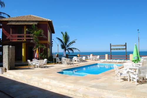 马拉塔伊济斯波尔塔巴拉旅馆的一个带游泳池和椅子的度假胜地和大海
