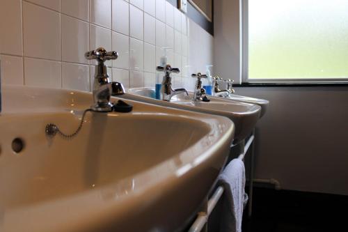 巴里那赫恩奇Ben Lettery Hostel的浴室水槽设有2个水龙头和窗户