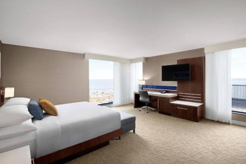 桑德贝Delta Hotels by Marriott Thunder Bay的酒店客房配有一张床、一张书桌和一台电视。
