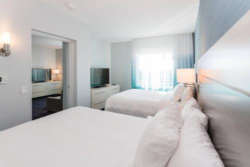 圣露西港TownePlace Suites Port St. Lucie I-95的酒店客房设有两张床和电视。
