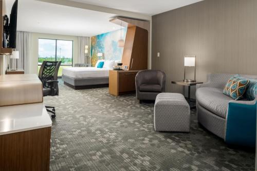 休斯顿Courtyard by Marriott Houston Northeast的酒店客房,配有床和沙发