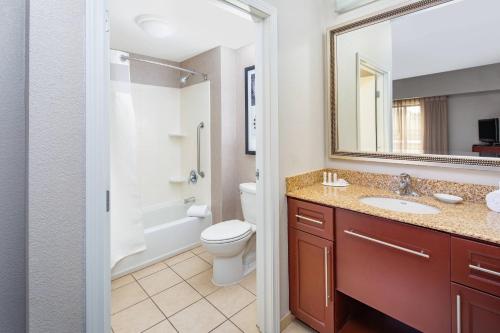 瑟普赖斯西北凤凰城/瑟普莱斯原住客栈的一间带卫生间、水槽和镜子的浴室