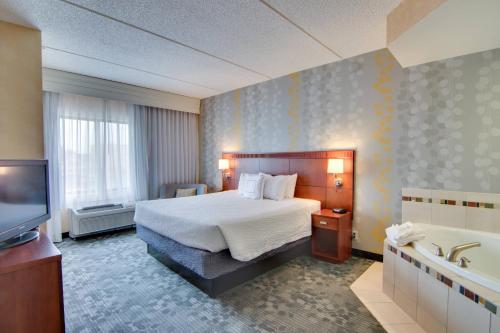 罗切斯特罗切斯特梅奥医学中心区区/圣玛丽万怡酒店的酒店客房设有床、浴缸和电视。