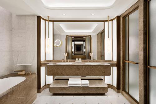 首尔Josun Palace, a Luxury Collection Hotel, Seoul Gangnam的浴室配有2个盥洗盆和1个浴缸。