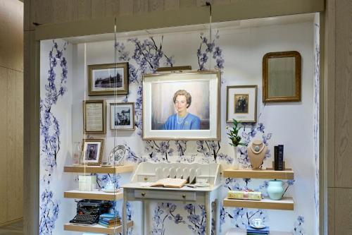 伯灵顿The Pearle Hotel & Spa, Autograph Collection的一间拥有蓝色和白色壁纸的房间,上面有一张女人的照片