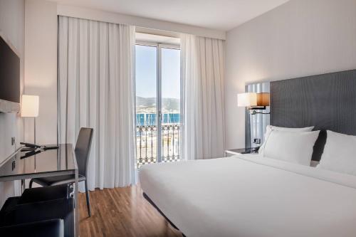 维戈帕拉西奥环球万豪AC酒店的一间酒店客房,设有一张大床和一个大窗户