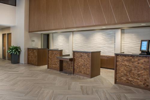 坦帕Marriott Tampa Westshore的办公大厅设有木制前台和大窗户