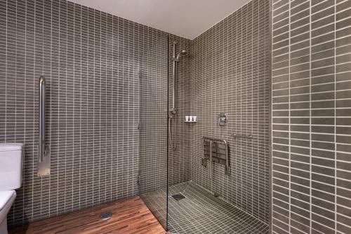 维戈帕拉西奥环球万豪AC酒店的带淋浴的浴室和玻璃门