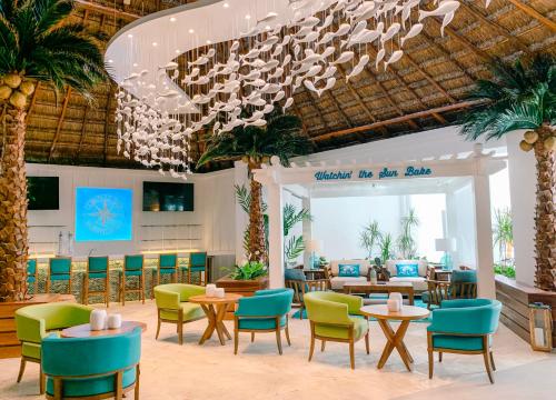 莫雷洛斯港Margaritaville Island Reserve Riviera Cancún - An All-Inclusive Experience for All的一间带桌椅和吊灯的餐厅
