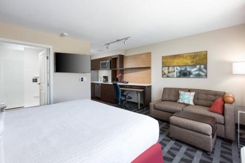 拉斯维加斯TownePlace Suites By Marriott Las Vegas Stadium District的酒店客房配有一张床、一张沙发和一张书桌。