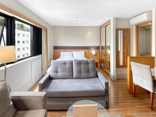圣保罗Hotel Corporativo na Faria Lima的客厅配有床和沙发