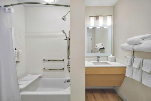 阿什维尔TownePlace Suites by Marriott Asheville West的带浴缸、水槽和镜子的浴室