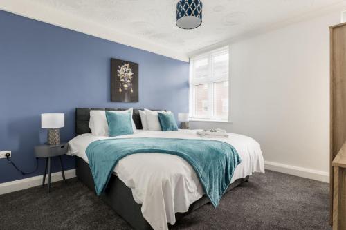 伯恩茅斯Lima Apartments Ltd-4 Beds-Large property -Long Stay Deal-Business-Parking的一间拥有蓝色墙壁和一张大床的卧室