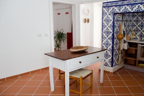 埃武拉Patinha Inn的厨房配有白色的桌子和凳子