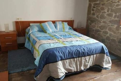 La Vega de RiosaCASONA SARIEGO, APARTAMENTO的一间卧室配有一张带蓝色床单和蓝色枕头的床。