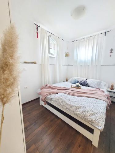 木洛希尼Apartment46的一间卧室配有一张带粉色毯子的床