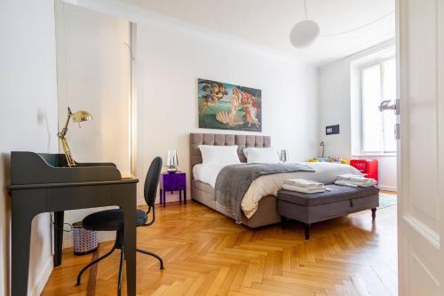 米兰B&B Liberty Suite Milan的卧室配有床、书桌和钢琴