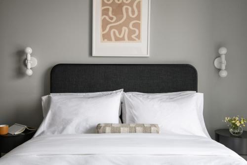 伯明翰Mint House Birmingham - Downtown的一间卧室配有一张白色的床和黑色床头板
