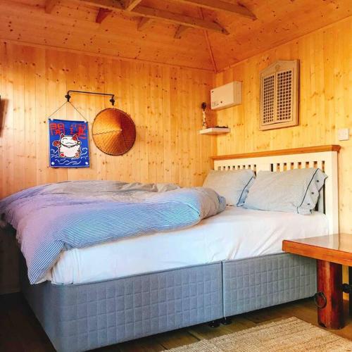 牛津Cosy Private Cabin with parking in good location的卧室配有木墙内的一张床
