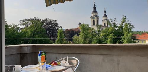 卢布尔雅那Apartments Katrca Ljubljana的阳台配有桌椅,与大楼相连