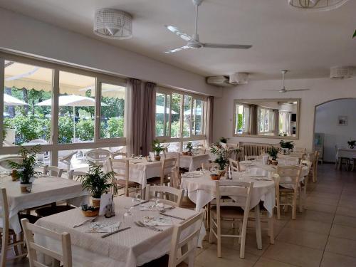 切塞纳蒂科B&b villa lambusta的餐厅设有白色的桌椅和窗户。