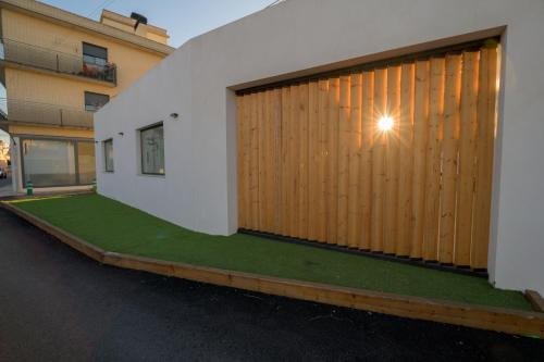 代尔特布雷Casa Casver的一座带绿色草坪的木车库门