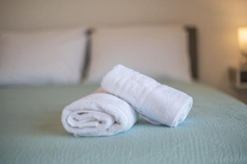 帕萨里迪Kos Helios House的床上的可卷起的白色毛巾