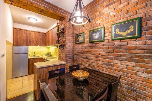 奥赫里德Ohrid Boutique Apartments的厨房里的砖墙,配有桌子