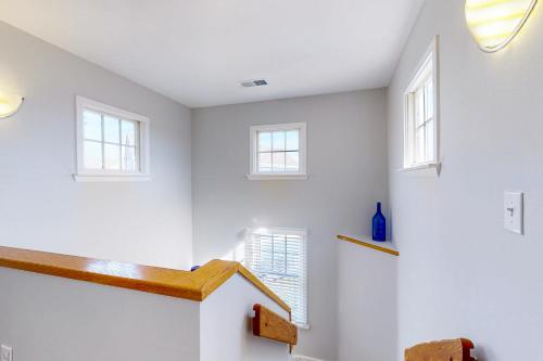 巴克斯顿Turtle #21B-CAC的一间拥有白色墙壁的客房和一个带窗户的楼梯