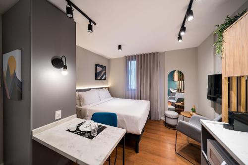 库里提巴Xtay Princess Curitiba的酒店客房配有一张床铺和一张桌子。