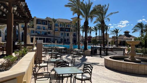 托雷帕切科Apartment in Mar Menor Golf Resort的酒店前方设有带桌椅的庭院。